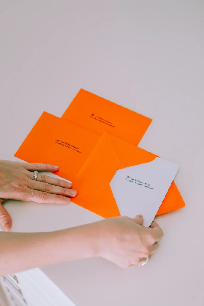 Hand greift nach orangefarbenen Flyern
